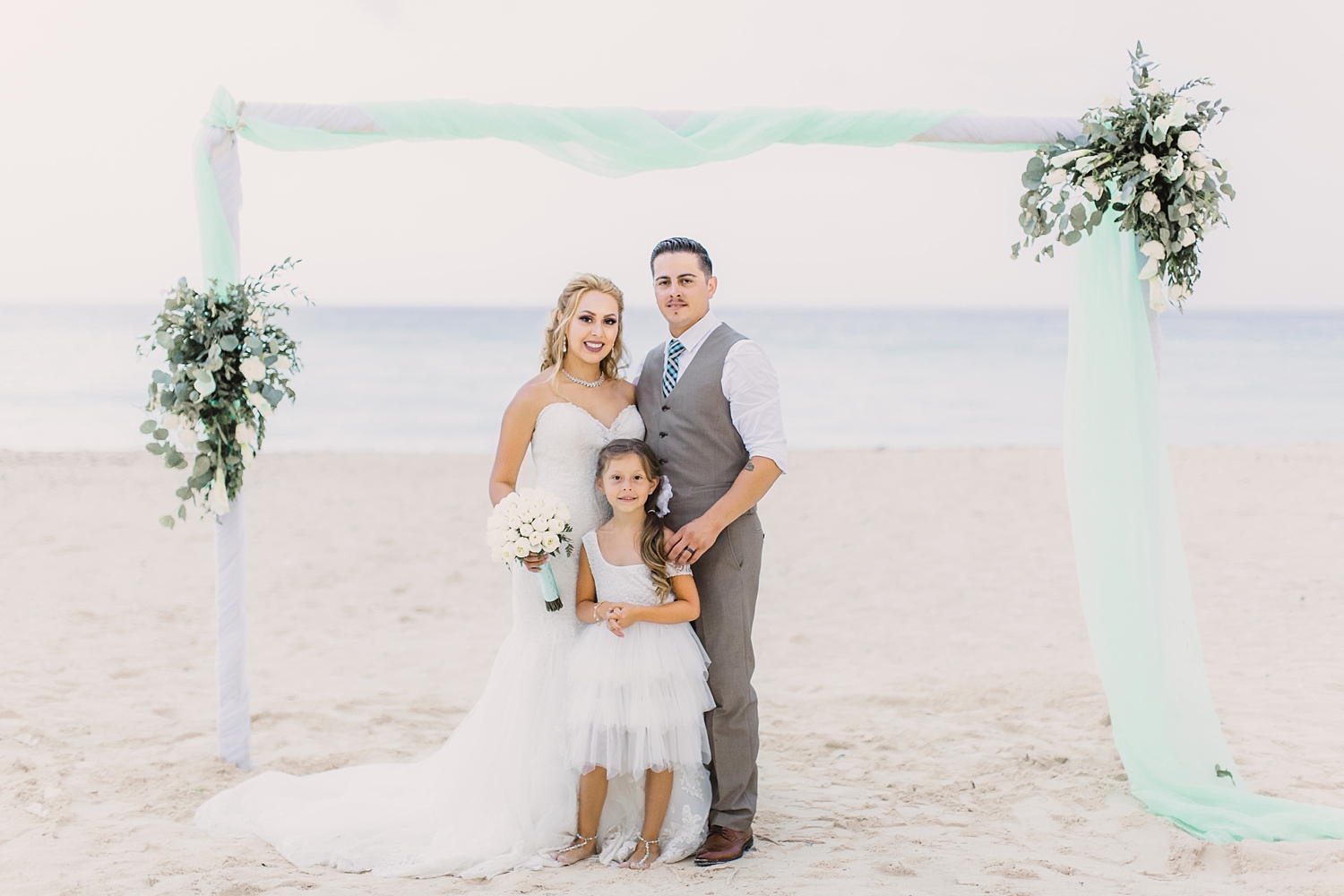 newlyweds family photo on beach in Oasis Cancun wedding