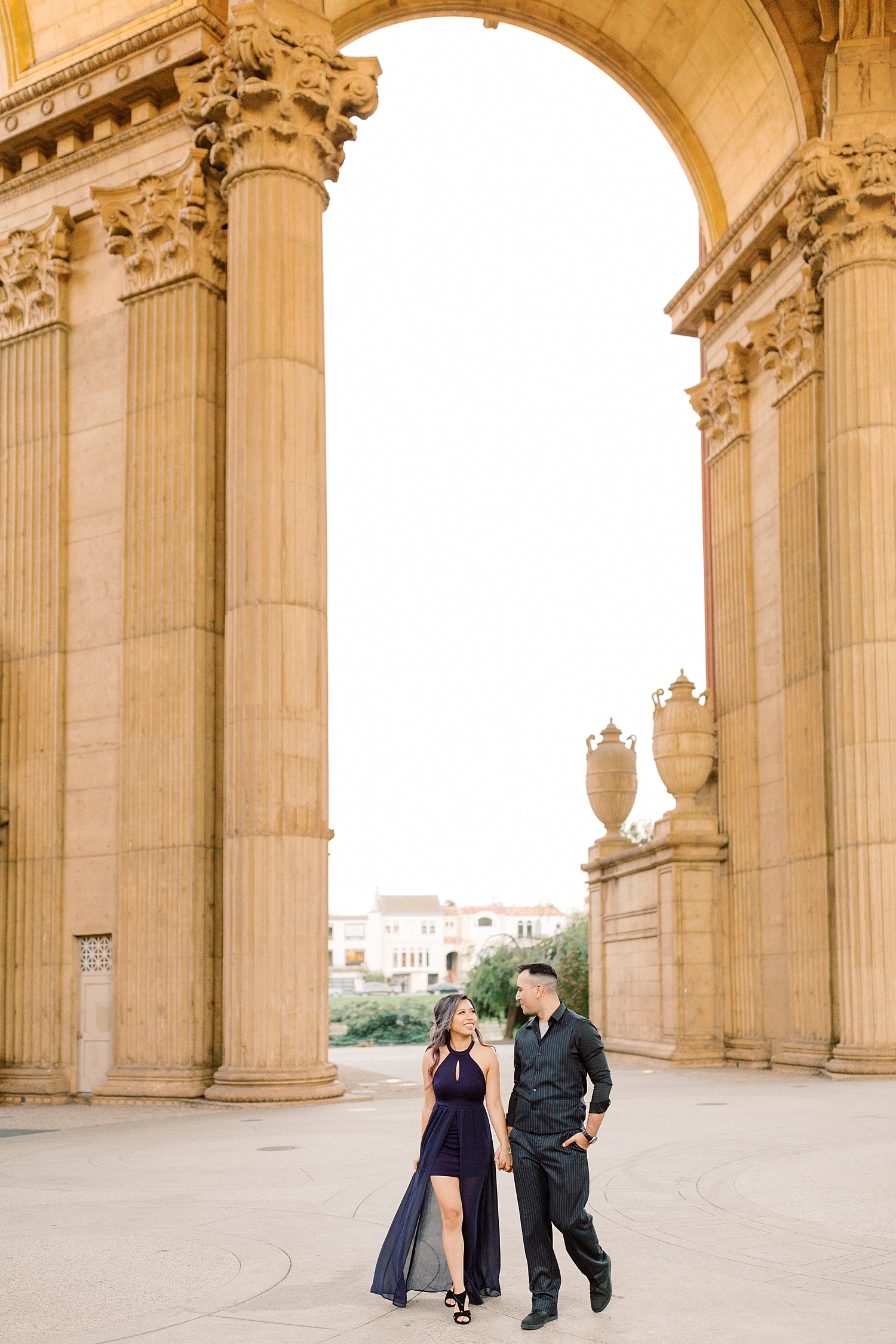engaged couple walking through the Palace of Fine Arts in San Francisco