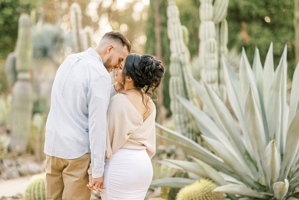 close-up landscape portrait of engaged couple leaning in to kiss in the Arizona cactus garden